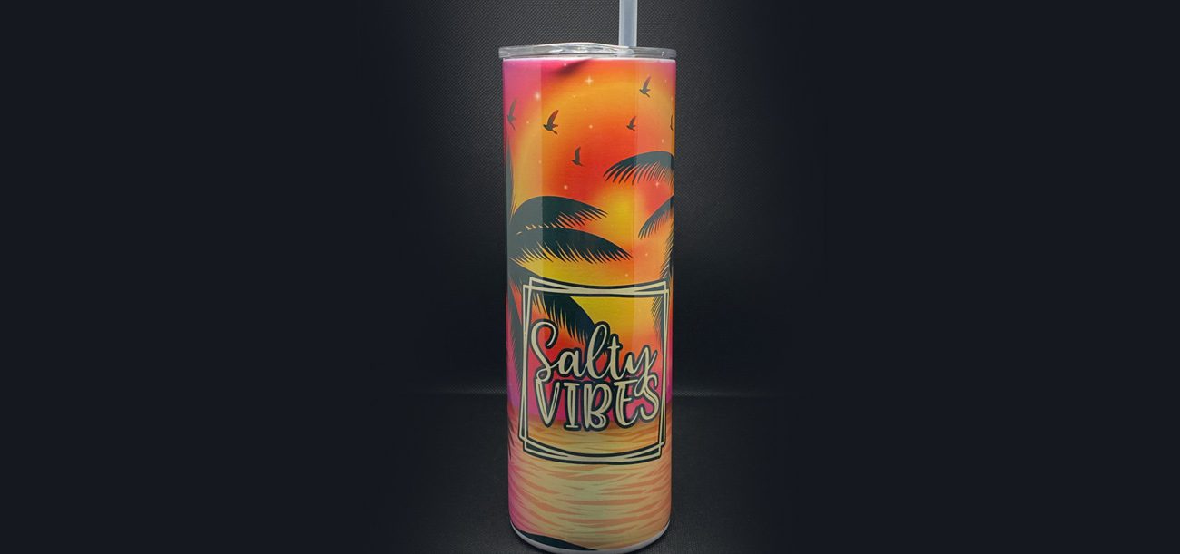 A tall skinny cup with a picture of watermelon and palm trees.