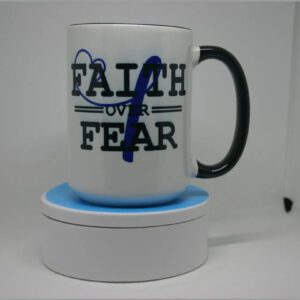 A coffee mug that says " faith over fear ".