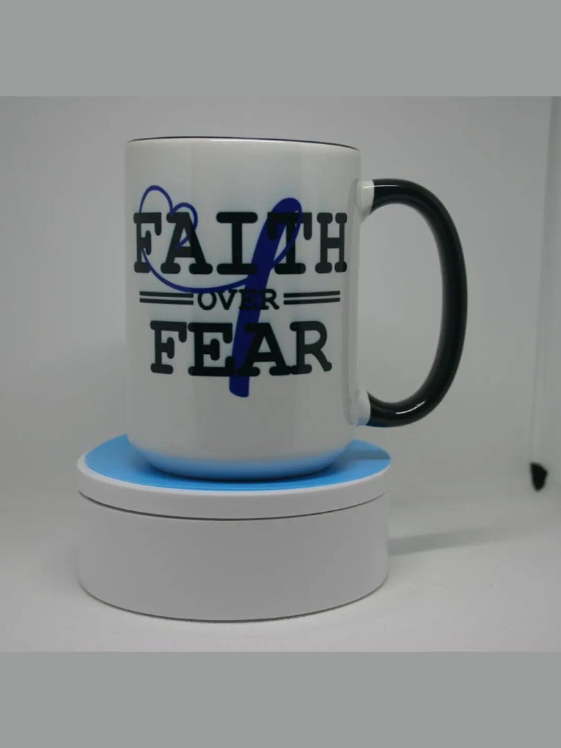 A coffee mug that says " faith over fear ".