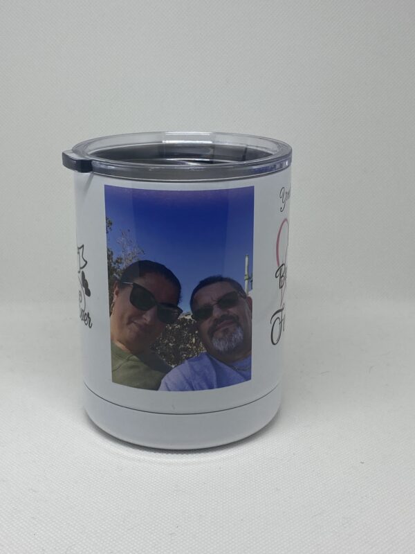 A couple is holding their picture on the side of a cup.