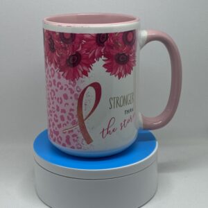 A pink coffee mug sitting on top of a blue coaster.