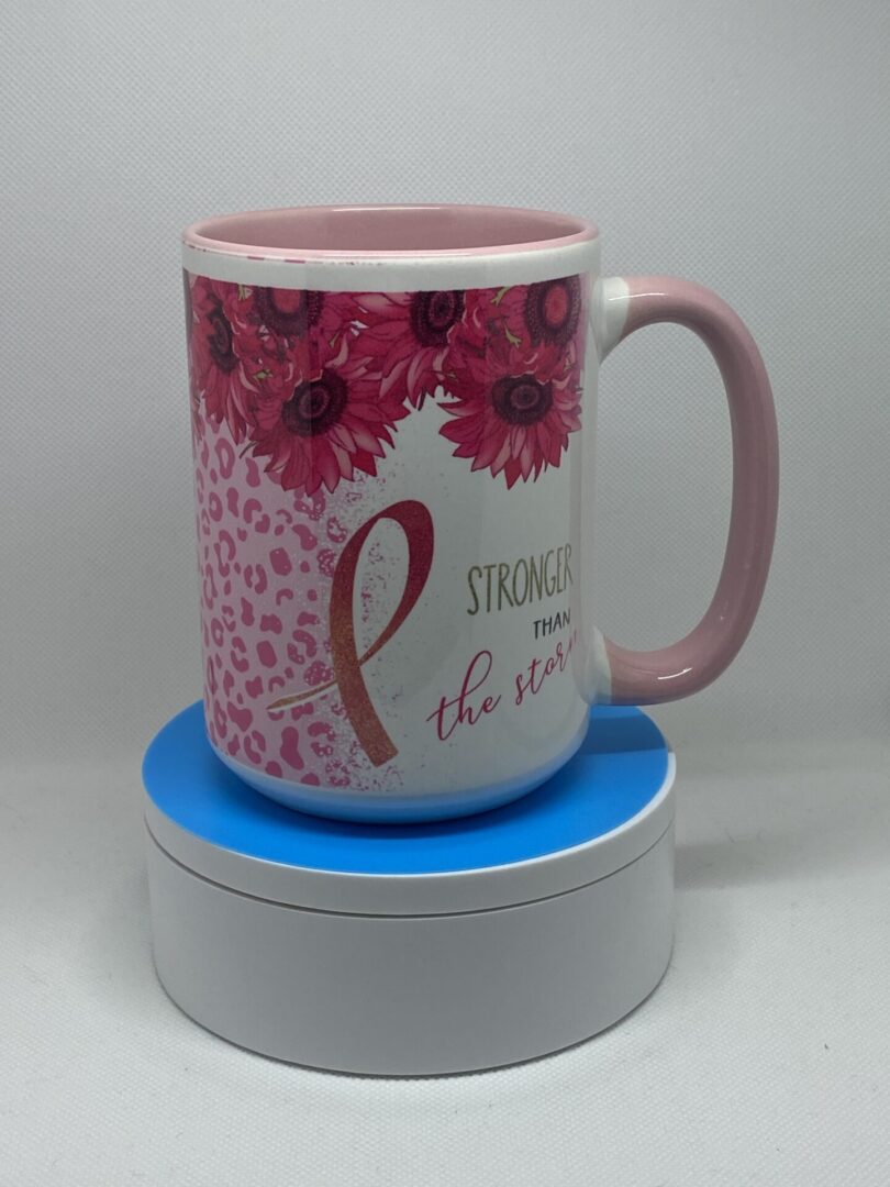 A pink coffee mug sitting on top of a blue coaster.