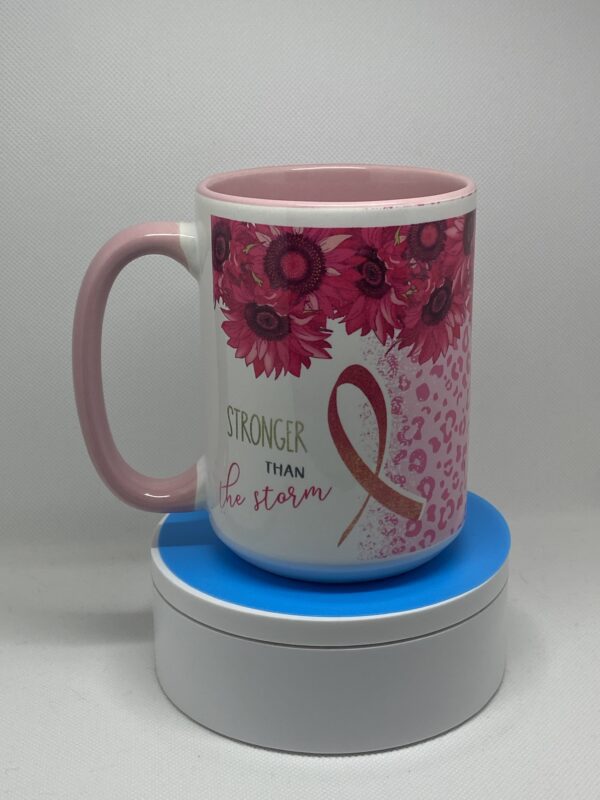 A pink mug with flowers and breast cancer ribbon.