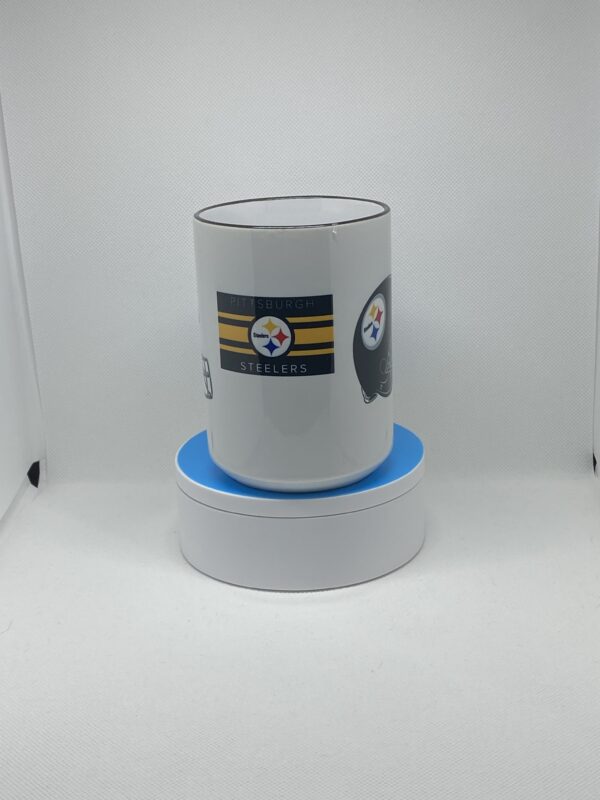 A steelers coffee mug sitting on top of a blue coaster.