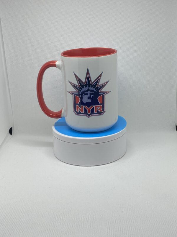 A red and white coffee mug sitting on top of a coaster.