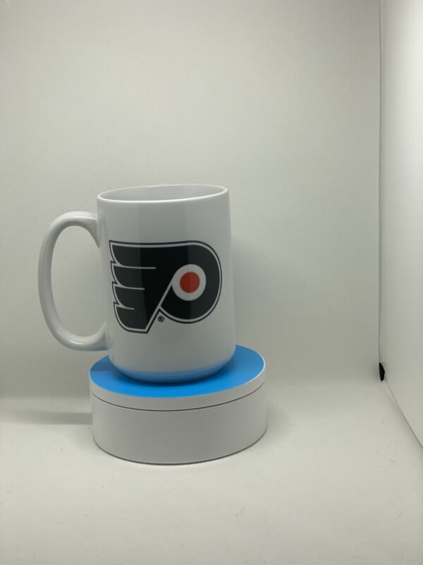 A white coffee mug sitting on top of a blue coaster.