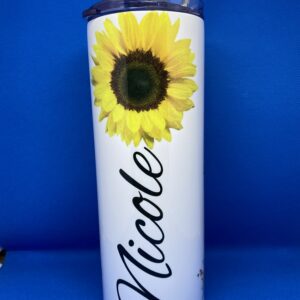 A sunflower is shown on the side of a white cup.