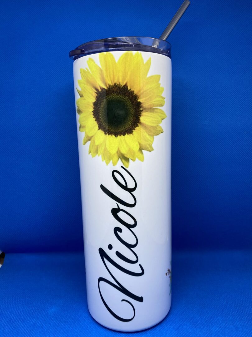 A sunflower is shown on the side of a white cup.