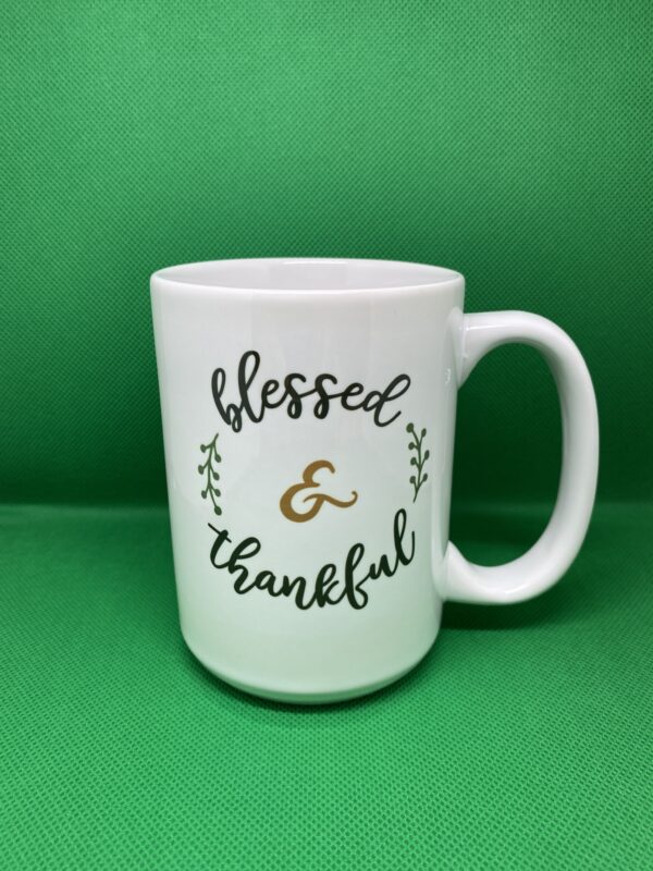 A coffee mug that says blessed and thankful.