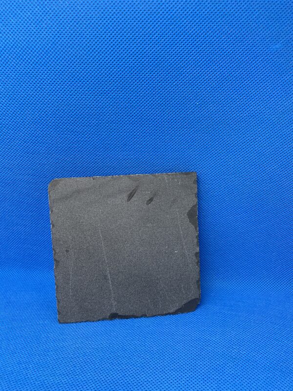 A piece of slate sitting on top of a blue surface.