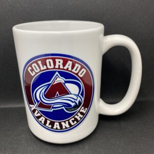 A white coffee mug with the colorado avalanche logo on it.