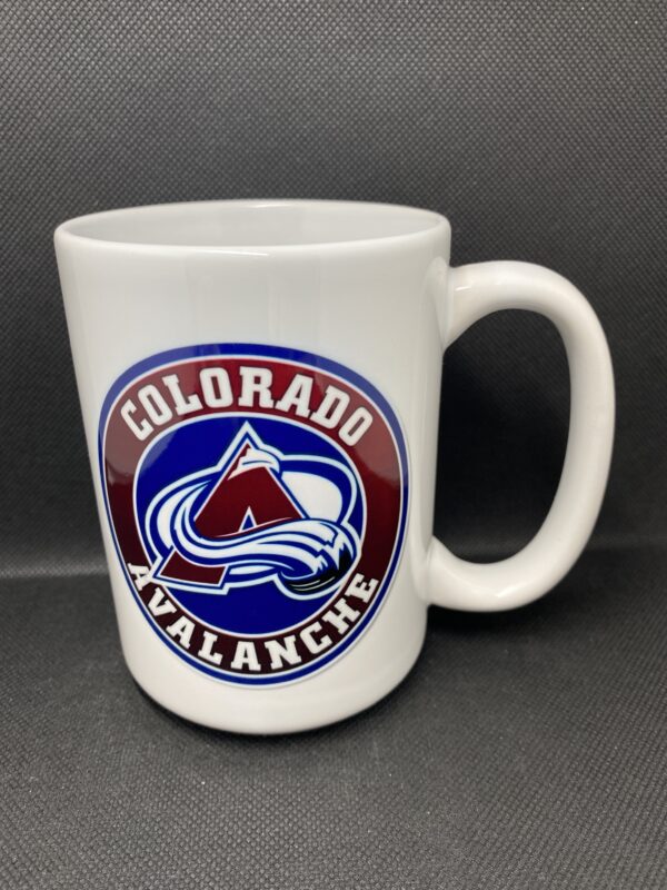 A white coffee mug with the colorado avalanche logo on it.