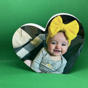 A baby with a yellow bow on its head.