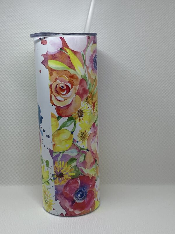 A tall skinny cup with flowers on it