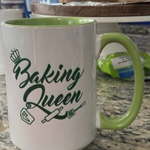 A coffee mug that says baking queen on it.