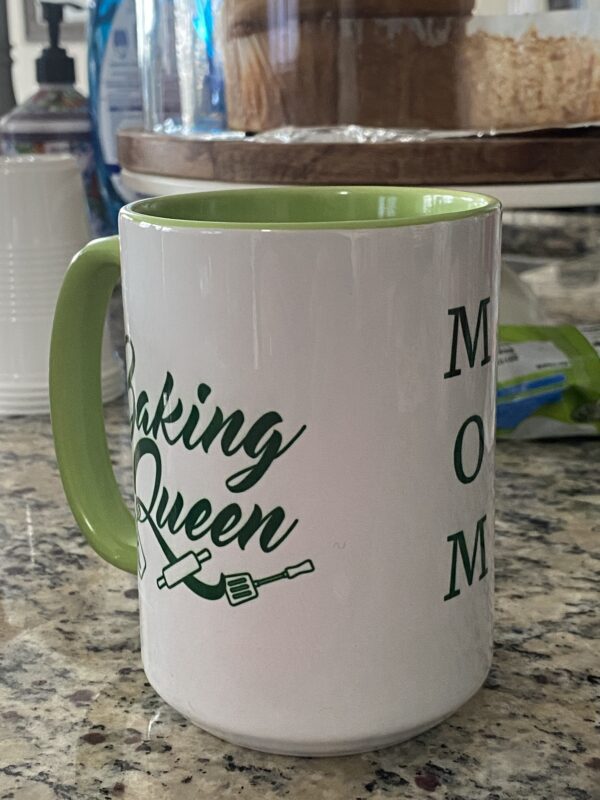 A coffee mug that says " making queen mom ".