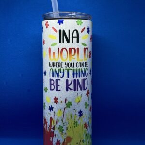 A cup that says " ina world where you can be anything, be kind ".