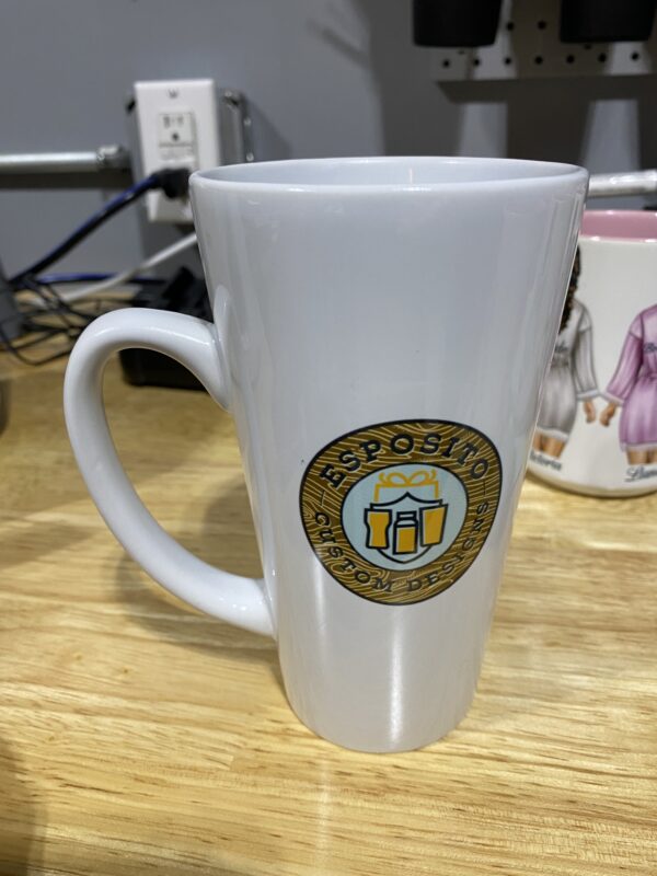 A white coffee mug sitting on top of a wooden table.