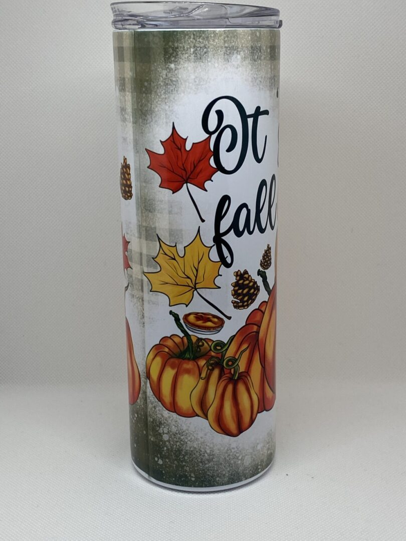 A candle that has fall themed designs on it.