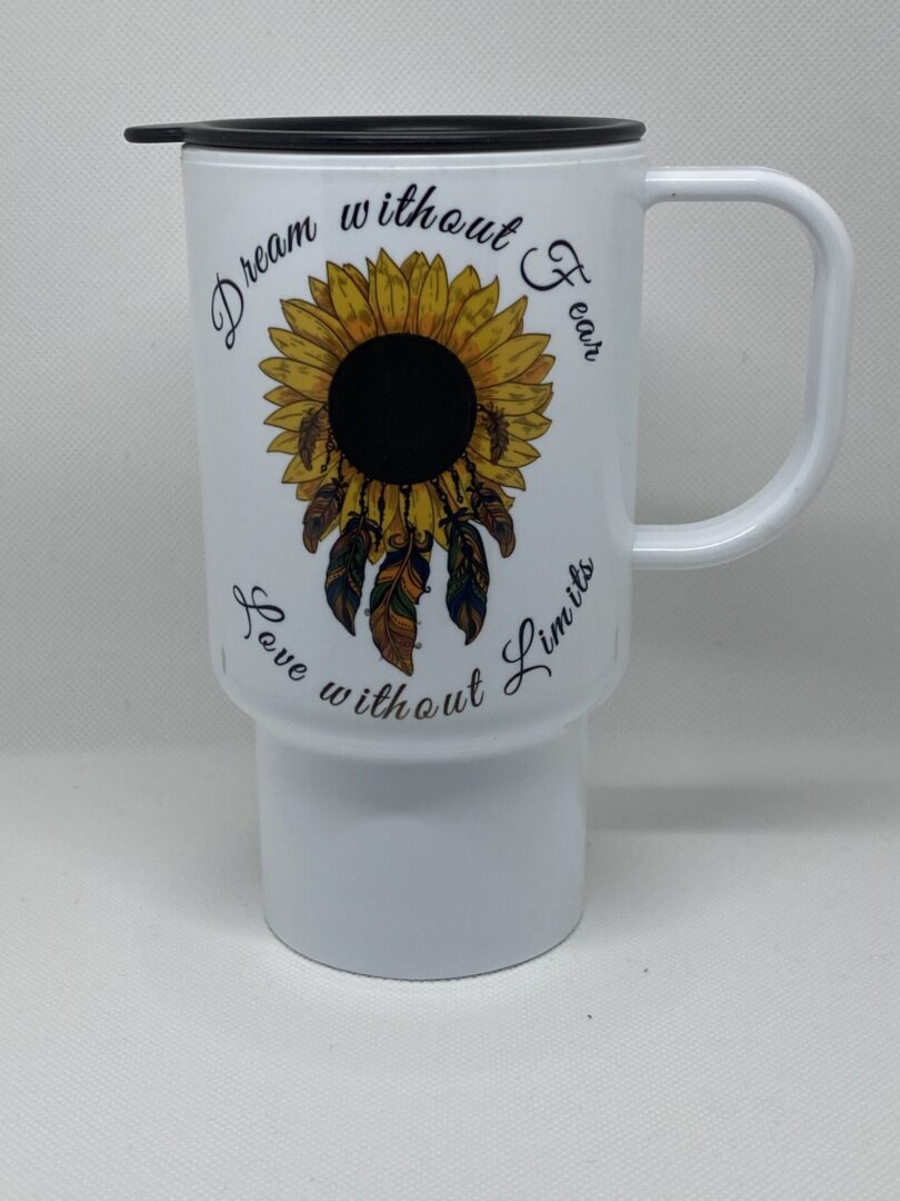 A white coffee mug with a sunflower and feathers.