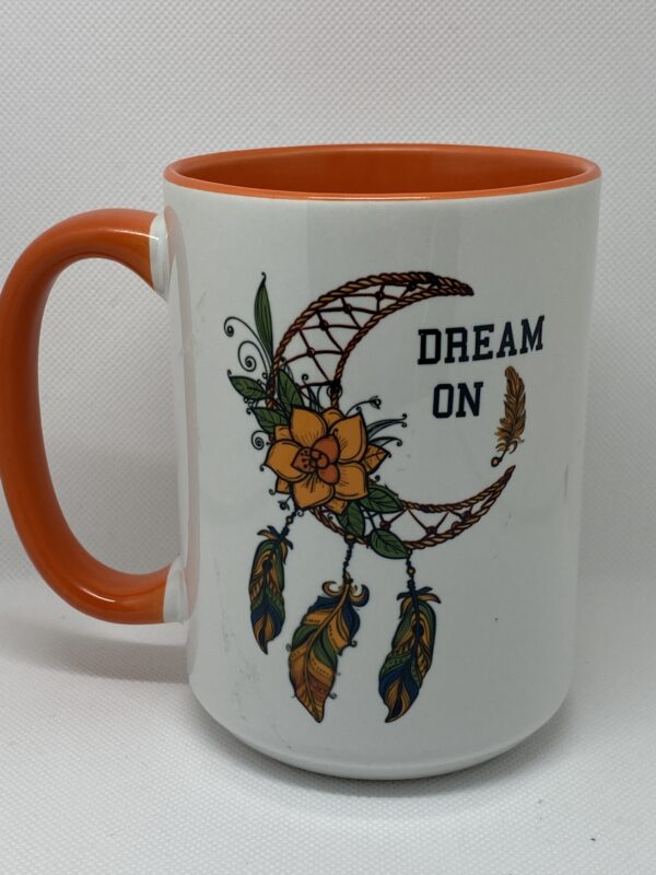 A coffee mug with the words " dream on ".