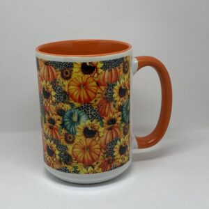 A coffee mug with an orange handle and a sunflower design.