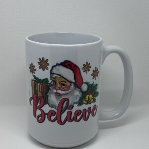 A white coffee mug with santa claus and the word " believe ".