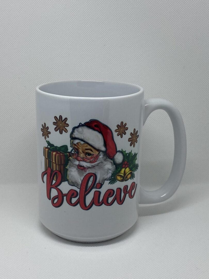 A white coffee mug with santa claus and the word " believe ".