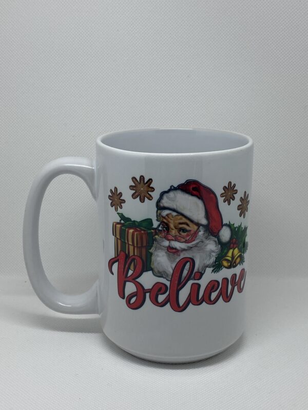 A white coffee mug with santa claus and the word believe.