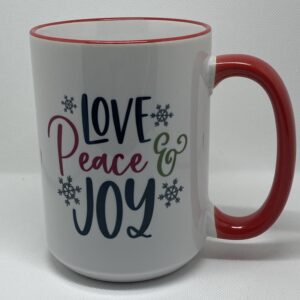 A coffee mug that says love peace and joy.