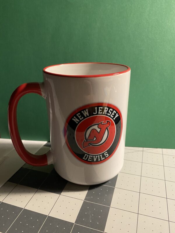 A new jersey devils coffee mug sitting on top of a table.