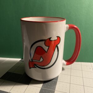 A mug with the new jersey devils logo on it.