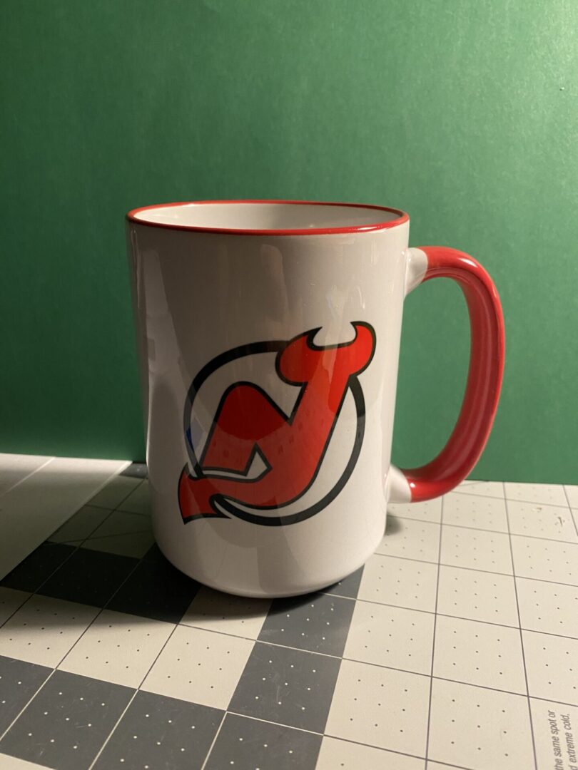 A mug with the new jersey devils logo on it.