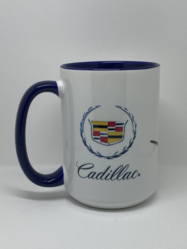 A white coffee mug with the words cadillac on it.