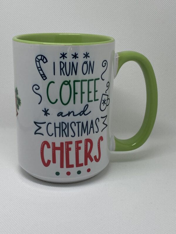 A coffee mug with the words " i run on coffee and christmas cheers ".