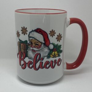 A coffee mug with santa claus and the words " believe ".