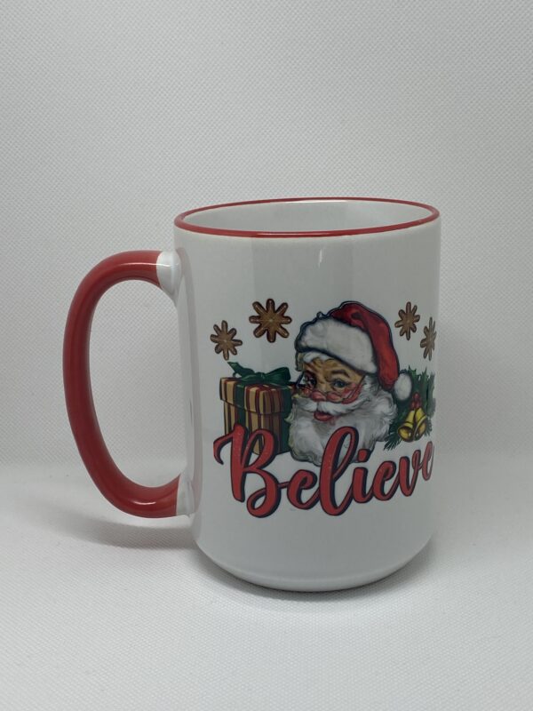 A white coffee mug with santa claus and the word " believe ".