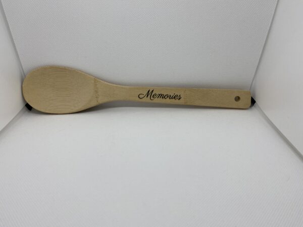 A wooden spoon with the word " memories " written on it.