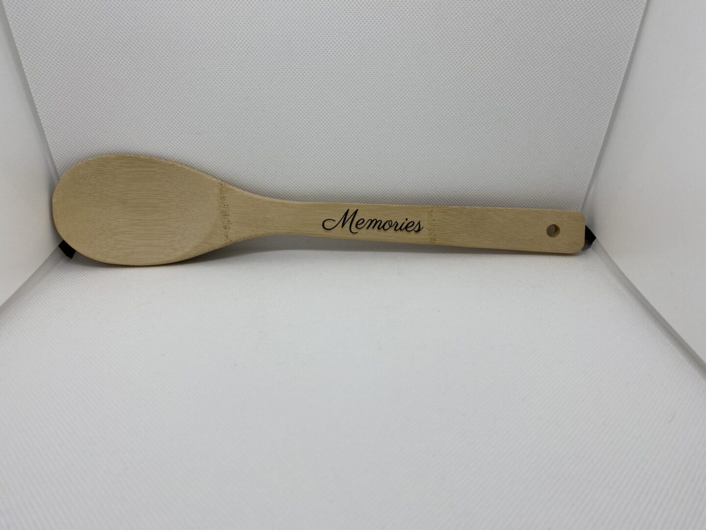 A wooden spoon with the word " memories " written on it.