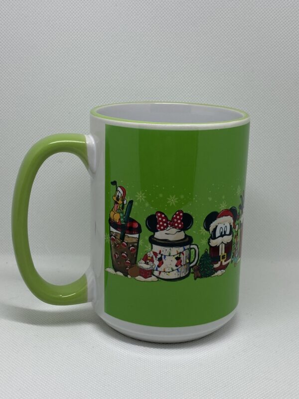 A green coffee mug with different characters on it.