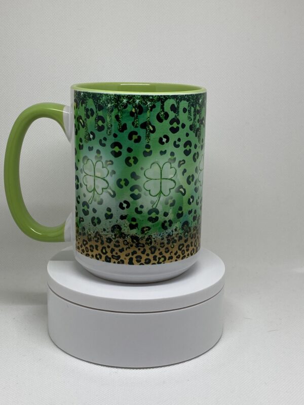 A green coffee mug with leopard print on it.