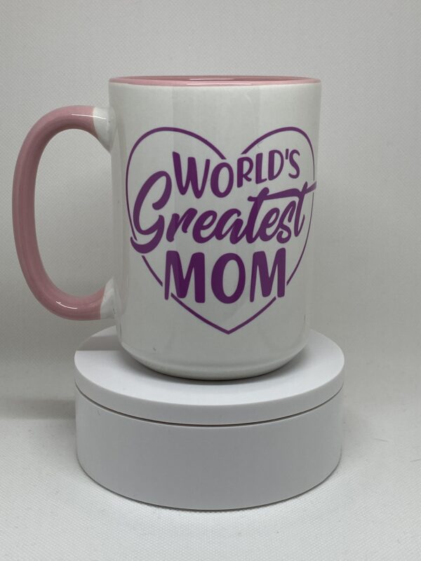 A pink and white coffee mug with the words " world 's greatest mom ".