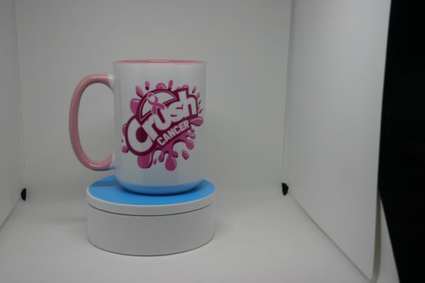 A pink and white coffee mug sitting on top of a coaster.