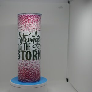 A tall pink and black candle on top of a blue stand.