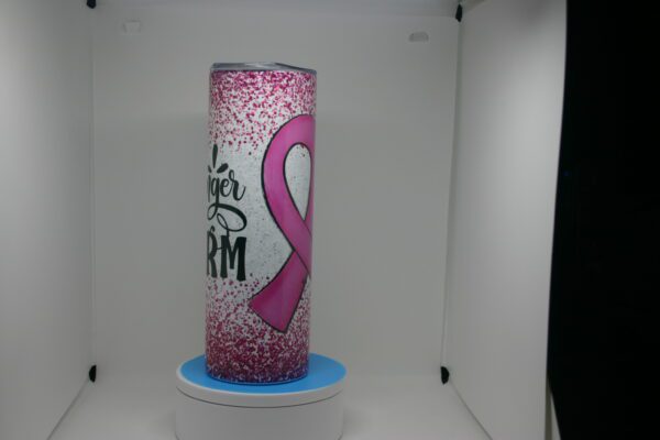 A pink ribbon candle is sitting on the counter.