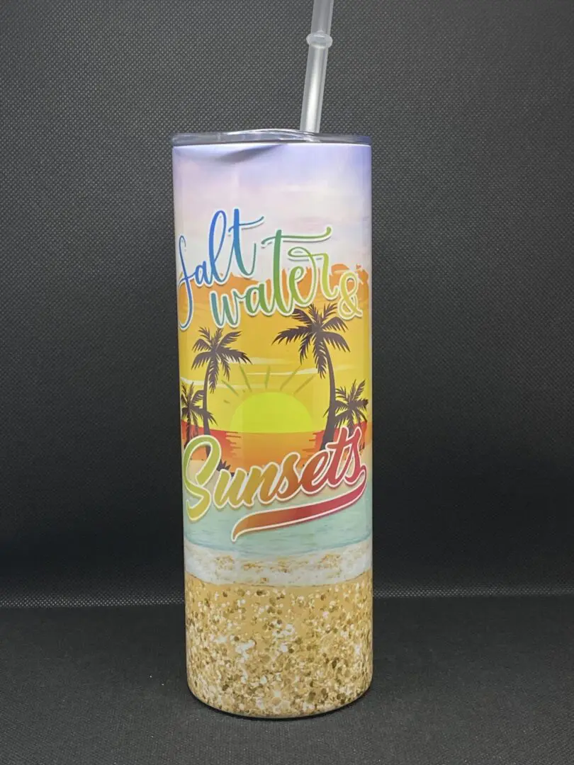 A tall cup with sand and palm trees on it.